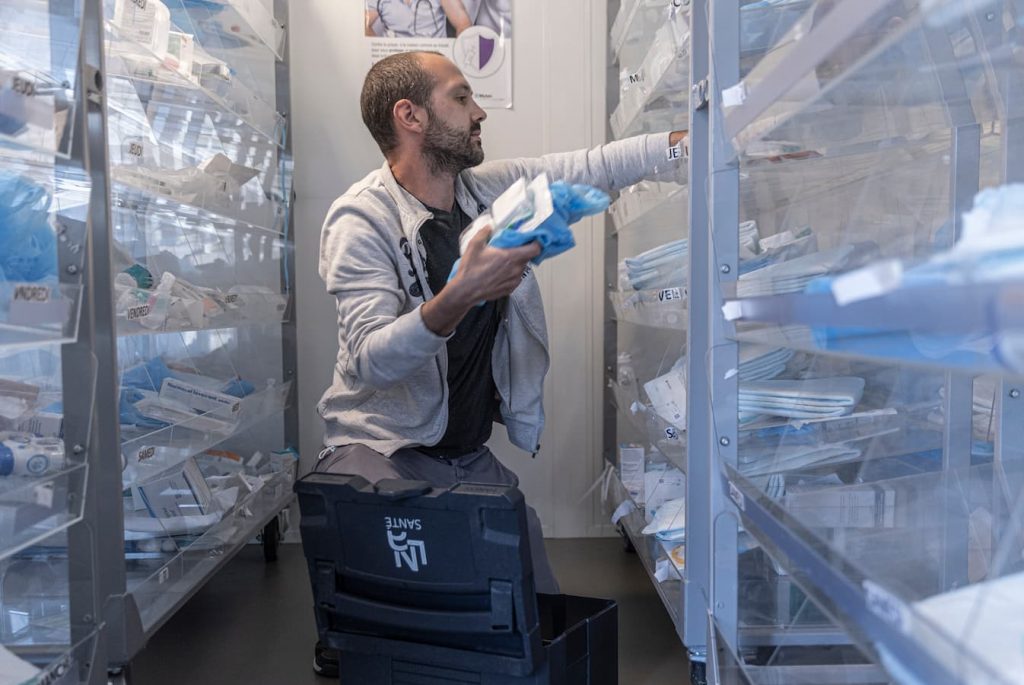 Soignant dans la pharmacie rempli sa mallette avec équipement de soins