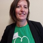 une femme avec un tee-shirt vert et une veste noire