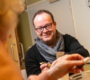 homme-avec-un-tee-shirt-noir-et-une-echarpe-gris